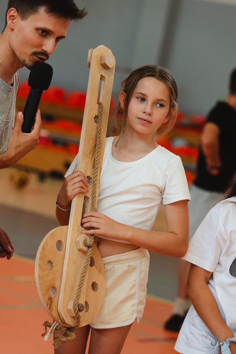 Dziewczynka trzyma zbudowany z elementów CoCreo instrument przypominający wielką gitarę